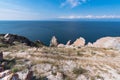 Cape Sagan-Khushun or Rocks Three brothers with red moss on the background of blue water and blue sky in summer time. Olkhon