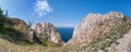 Cape Sagan-Khushun or Rocks Three brothers with red moss on the background of blue water and blue sky. Summer on Olkhon, Baikal