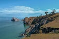 Cape Shamanka in clear blue Lake Baikal among the grassy steppes with coniferous larch trees, rocks Royalty Free Stock Photo