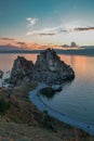 Cape Shamanka rock in clear blue Lake Baikal among rocks, coast, colorful pink sunset Royalty Free Stock Photo