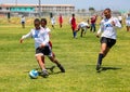 Diverse children playing soccer football at school