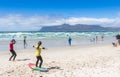 Surfing coach at Muizenberg beach teaching a young girl to surf at Surfers Corner