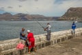 Anglers on the harbor wall at Kalk Bay South Africa Royalty Free Stock Photo