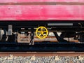 Yellow wheel on the side of a colorful train.