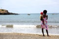 Cape Verdean woman with a child on the beach