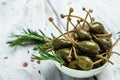Capers. Marinated or pickled canned capers fruit with fresh rosemary in a small bowl, on gray background. place for text, top view Royalty Free Stock Photo