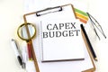 CAPEX BUDGET text on notebook with clipboard on white background