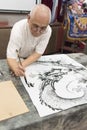 Master painting a chinese dragon, with black Chinese ink Royalty Free Stock Photo