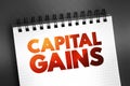 Capital gains - increase in a capital asset\'s value and is realized when the asset is sold, text concept on notepad