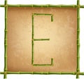 Capital letter E made of green bamboo sticks on old paper background Royalty Free Stock Photo