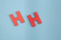 Capital letters H in red color arranged on blue background.