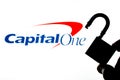 Capital One Bank logo on the screen in a main focus and a blurred silhouette of the open lock. Conceptual photo for news about the