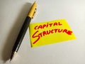 capital structure text displayed on yellow paper slip with red colour alphabets with pen concept Royalty Free Stock Photo