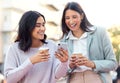 Capitalise on your network and wealth will come. two young businesswomen using a smartphone against an urban background. Royalty Free Stock Photo