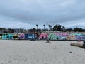 Capitola beach view with colorful houses, trees, and some people sitting in the sand, California