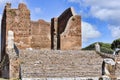 The Capitolium at archaeological excavations of Ostia Antica surrounded by ruins, columns and remains of statues and bas-reliefs