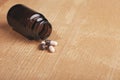 Caplets or pills in front of the opening medicine bottle