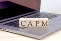 CAPM word on wooden block on laptop, business concept Royalty Free Stock Photo