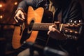 With a capo and acoustic guitar, the musician harmonizes with a nearby microphone. Royalty Free Stock Photo