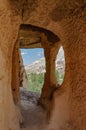 Cappadocia from inside cave house. Impressive fairy chimneys of sandstone in the canyon near Cavusin village, Cappadocia, Nevsehir Royalty Free Stock Photo