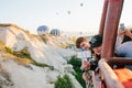 Cappadocia, June 12, 2017: Asian tourists shoot video on iPhone during hot air balloon flight against the background of