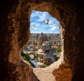 Cappadocia`s beautiful view through the window hole - landscape view with flying balloons and cave castles