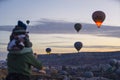 10.11.2022 Cappadocia, Turkey. Blurred parent holding his child piggy back in the foreground, watching stunning