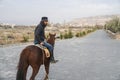 Cappadocia / Turkey - December 7 2019: cool man with middle age on horse back walking on the street town to Rose Valley Royalty Free Stock Photo