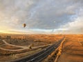 Cappadocia / Turkey - December 5 2019: long concrete road with bright morning sunlight and floating hot air balloon