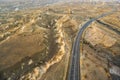 Cappadocia / Turkey - December 6 2019: top view of long curve concrete road with high hills and hot air balloons Royalty Free Stock Photo