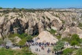 Tourists exploring rock formations and cave houses, Goreme national park, underground city, Cappadocia Turkey