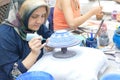 Artist paints unfired pottery in Avanos