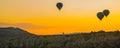 Cappadocia, Turkey: The silhouettes of the balloons early in the morning on a background of yellow-orange sky