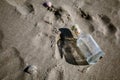 Capped by cork empty, without message, glass bottle by sand sea beach.  A symbol of hopeless hopes, shattered dreams, despair and Royalty Free Stock Photo