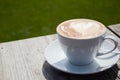 Cappucchino on a wooden table in the sun Royalty Free Stock Photo