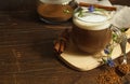 cappuccino from chicory root, decorated with cinnamon and flower, on a dark wooden background, horizontal with space