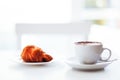 Cappuccino coffee and croissant on white background