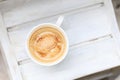 Cappuccino coffee in a cup on a white wooden table. Top view, copy space. Royalty Free Stock Photo