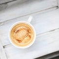 Cappuccino coffee in a cup on a white wooden table. Top view, copy space. Royalty Free Stock Photo