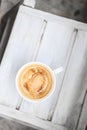 Cappuccino coffee in a cup on a white wooden table. Top view, copy space. Royalty Free Stock Photo