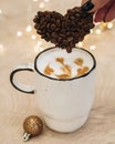 Cappuccino coffee is poured into a white mug. Heart made from coffee beans. Royalty Free Stock Photo