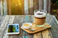 Cappuccino coffee with smartphone on wood texture background. breakfast on morning or coffee time. working and relaxing time. Royalty Free Stock Photo