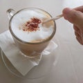 Cappuccino coffee in transparent glass cup