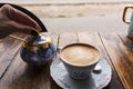 Cappuccino coffee, in vintage porcelain cup, on the wooden table