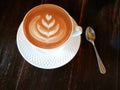 Cappuccino coffee in white cup on dark wood table