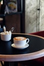 Cappuccino cup of coffee with sugar on the table in restaurant side view and a lot of copy space. Coffee cup latte and Royalty Free Stock Photo