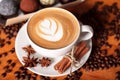 Cappuccino Cup with latte art on a wooden table with coffee beans, anise, cinnamon. Spending time with a Cup of coffee Royalty Free Stock Photo