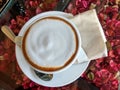 Cappuccino cup and latte art on the blurred red flora table