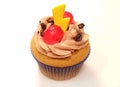 Cappuccino cupcake with a yellow candy and a red cherry on top Royalty Free Stock Photo