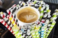 cappuccino paper cup between many colorful paper straws